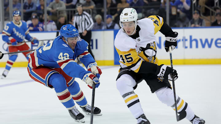 Oct 7, 2025; New York, New York, USA; Pittsburgh Penguins defenseman Harrison Brunicke (45) plays the puck against New York Rangers center Noah Laba (42) during the third period at Madison Square Garden. Mandatory Credit: Brad Penner-Imagn Images