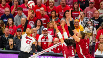 Oct 21, 2023; Lincoln, NE, USA; Nebraska Cornhuskers outside hitter Harper Murray (27) attacks against Wisconsin Badgers middle blocker Caroline Crawford (9) and middle blocker Anna Smrek (14) during the first set.