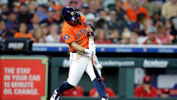 May 9, 2025; Houston, Texas, USA; Houston Astros designated hitter Jose Altuve (27) hits a double to left field against the Cincinnati Reds during the third inning at Daikin Park. 