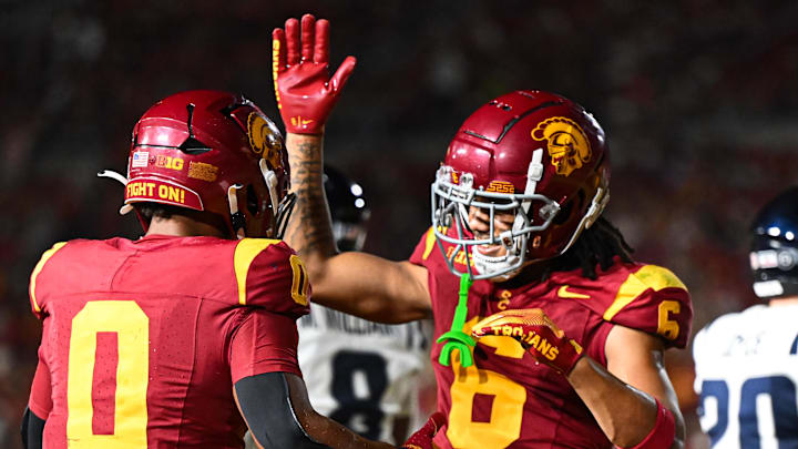 Sep 7, 2024; Los Angeles, California, USA; USC Trojans running back Quinten Joyner (0) celebrates with USC Trojans wide receiver Makai Lemon (6) after scoring a touchdown against the Utah State Aggies during the third quarter at United Airlines Field at Los Angeles Memorial Coliseum. Mandatory Credit: Jonathan Hui-Imagn Images