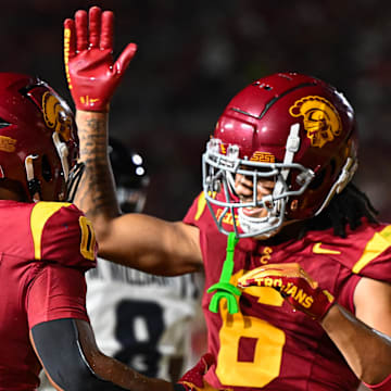 Sep 7, 2024; Los Angeles, California, USA; USC Trojans running back Quinten Joyner (0) celebrates with USC Trojans wide receiver Makai Lemon (6) after scoring a touchdown against the Utah State Aggies during the third quarter at United Airlines Field at Los Angeles Memorial Coliseum.