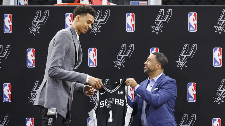 Jun 24, 2023; San Antonio, TX, USA; San Antonio Spurs draft pick Victor Wembanyama (left) is presented with a jersey by general manager Brian Wright during a press conference at AT&T Center. Mandatory Credit: Troy Taormina-USA TODAY Sports