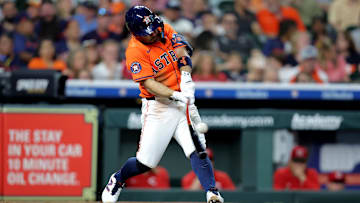 May 9, 2025; Houston, Texas, USA; Houston Astros designated hitter Jose Altuve (27) hits a double to left field against the Cincinnati Reds during the third inning at Daikin Park. 