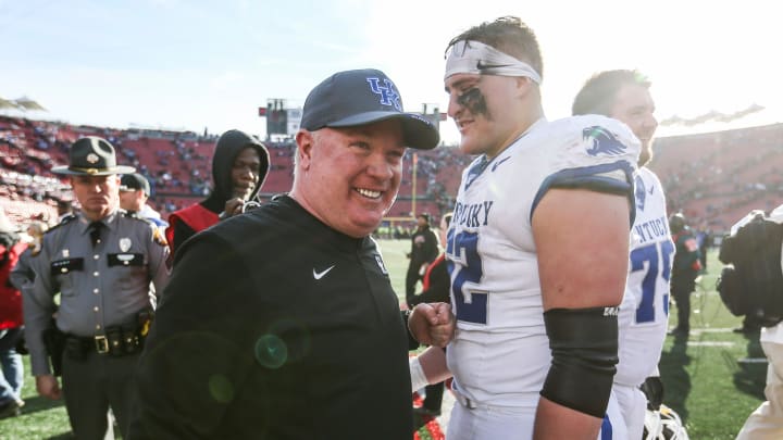 Kentucky Wildcats head coach Mark Stoops smiles with Kentucky Wildcats offensive lineman Jager Burton (62) after the Wildcats beat Louisville 38-31 Saturday. Nov. 24, 2023