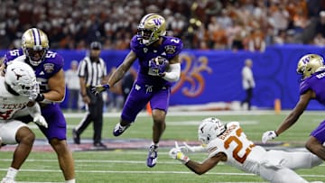 Jan 1, 2024; New Orleans, LA, USA; Washington Huskies wide receiver Ja'Lynn Polk (2) leaps over Texas Longhorns defensive back Jahdae Barron (23) during the third quarter of the 2024 Sugar Bowl college football playoff semifinal game at Caesars Superdome. Mandatory Credit: Geoff Burke-Imagn Images