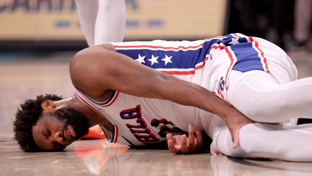 Nov 19, 2023; Brooklyn, New York, USA; Philadelphia 76ers center Joel Embiid (21) grabs his right leg after falling to the court during the third quarter against the Brooklyn Nets at Barclays Center. Mandatory Credit: Brad Penner-USA TODAY Sports