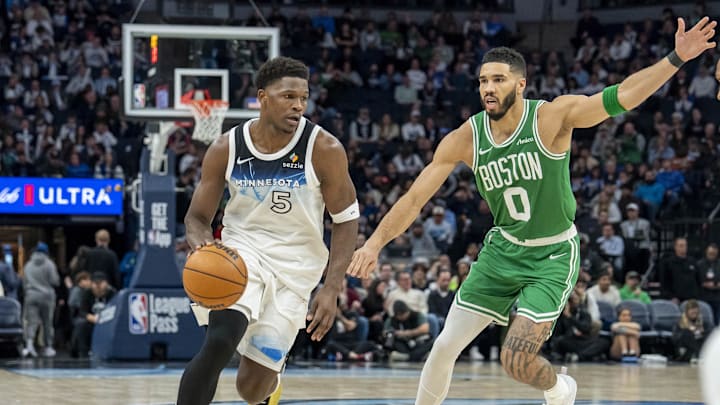 Jan 2, 2025; Minneapolis, Minnesota, USA; Minnesota Timberwolves guard Anthony Edwards (5) dribbles past Boston Celtics forward Jayson Tatum (0) in the second half at Target Center. Mandatory Credit: Jesse Johnson-Imagn Images