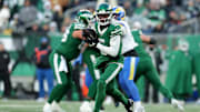 Dec 22, 2024; East Rutherford, New Jersey, USA; New York Jets wide receiver Garrett Wilson (5) runs with the ball against the Los Angeles Rams during the fourth quarter at MetLife Stadium.