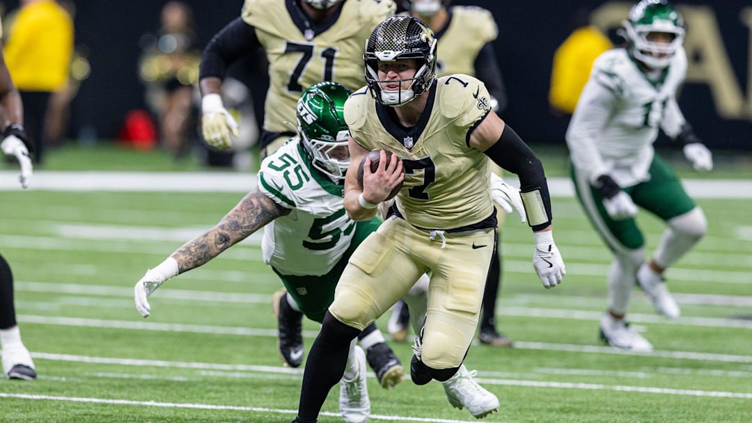 Dec 21, 2025; New Orleans, Louisiana, USA;  New Orleans Saints tight end Taysom Hill (7) runs away from the tackle of New York Jets defensive end Braiden McGregor (55) during the second half  at Caesars Superdome. Mandatory Credit: Stephen Lew-Imagn Images