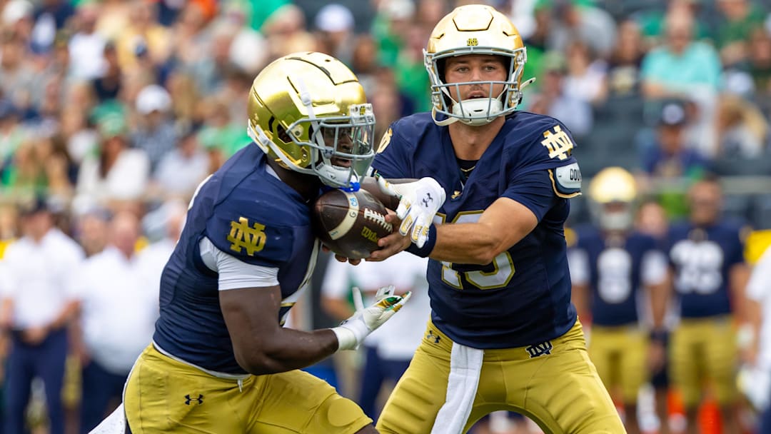Sep 20, 2025; South Bend, Indiana, USA; Notre Dame Fighting Irish quarterback CJ Carr (13) hands off to Notre Dame Fighting Irish running back Jeremiyah Love (4) against the Purdue Boilermakers during the first half at Notre Dame Stadium. Mandatory Credit: Michael Caterina-Imagn Images