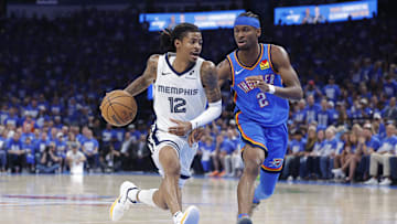 Memphis Grizzlies guard Ja Morant (12) drives to the basket beside Oklahoma City Thunder guard Shai Gilgeous-Alexander (2) in the third quarter during game two of first round for the 2024 NBA Playoffs at Paycom Center. Mandatory Credit: Alonzo Adams-Imagn Images