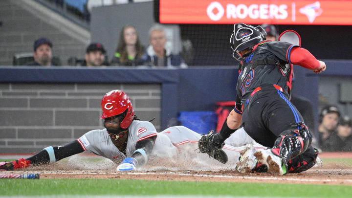 Aug 21, 2024; Toronto, Ontario, CAN;  Cincinnati Reds shortstop Elly De La Cruz (44) slides home to score a run past the tag attempt of Toronto Blue Jays catcher Brian Serven (15) in the fifth inning at Rogers Centre. Mandatory Credit: Dan Hamilton-USA TODAY Sports