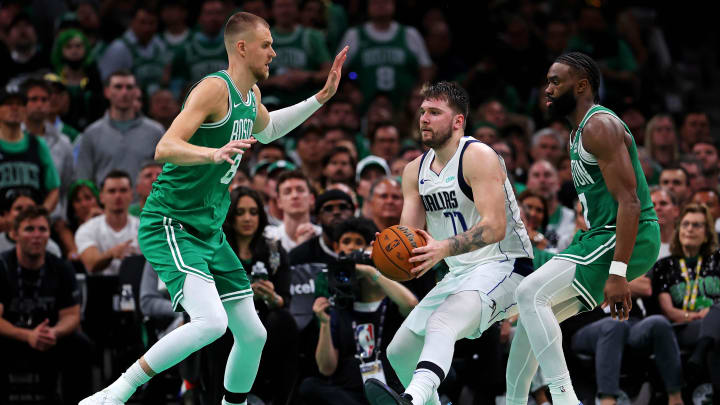 Jun 17, 2024; Boston, Massachusetts, USA; Dallas Mavericks guard Luka Doncic (77) handles the ball against Boston Celtics guard Jaylen Brown (7) and center Kristaps Porzingis (8) in game five of the 2024 NBA Finals at TD Garden. Mandatory Credit: Peter Casey-USA TODAY Sports