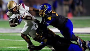 St. Augustine's Devonte Lyons (6) is tackled by Brunswick's Mike Daniels Jr. (34), right top, and Donyea Broughton (88), bottom, during the first quarter of the Florida-Georgia Border Classic high school football matchup Saturday, Sept. 9, 2023 at Glynn County Stadium in Brunswick, Ga. The St. Augustine Yellow Jackets held off the Brunswick Pirates 45-35.