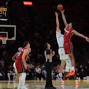 Nov 7, 2025; Miami, Florida, USA; Miami Heat center Kel'el Ware (7) wins the tip-off against Charlotte Hornets center Ryan Kalkbrenner (11) during the first quarter of an NBA Cup game at Kaseya Center. Mandatory Credit: Sam Navarro-Imagn Images