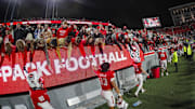 Nov 29, 2025; Raleigh, North Carolina, USA;  NC State Wolfpack fans celebrate with the team after the second half of the game against North Carolina Tar Heels at Carter-Finley Stadium.  Mandatory Credit: Jaylynn Nash-Imagn Images
