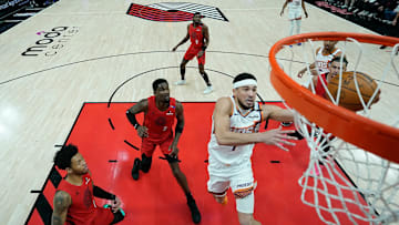 Phoenix Suns guard Devin Booker glides toward the basket for a layup in a game against the Portland Trail Blazers.