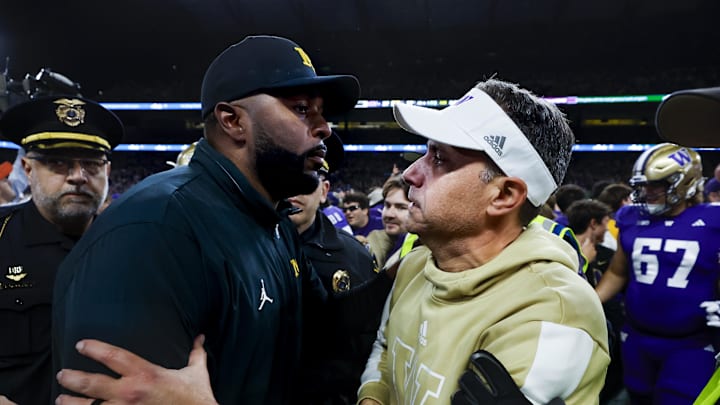 Oct 5, 2024; Seattle, Washington, USA; Michigan Wolverines head coach Sherrone Moore, left, shakes hands with Washington Huskies head coach Jedd Fisch, right, following a Washington victory at Alaska Airlines Field at Husky Stadium. Mandatory Credit: Joe Nicholson-Imagn Images