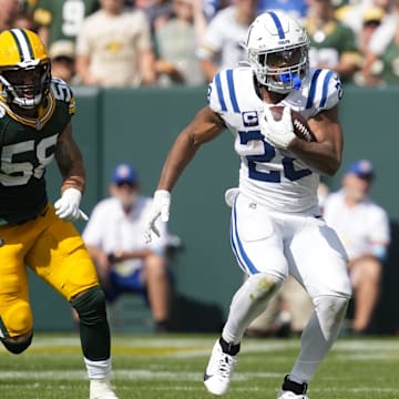 Sep 15, 2024; Green Bay, Wisconsin, USA;  Indianapolis Colts running back Jonathan Taylor (28) rushes with the football in front of Green Bay Packers linebacker Isaiah McDuffie (58) during the third quarter at Lambeau Field. Mandatory Credit: Jeff Hanisch-Imagn Images