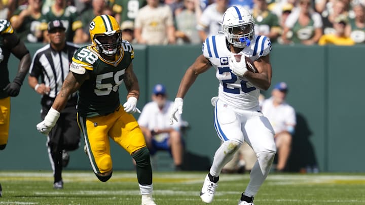 Sep 15, 2024; Green Bay, Wisconsin, USA;  Indianapolis Colts running back Jonathan Taylor (28) rushes with the football in front of Green Bay Packers linebacker Isaiah McDuffie (58) during the third quarter at Lambeau Field. Mandatory Credit: Jeff Hanisch-Imagn Images