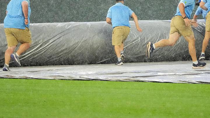 Jun 12, 2025; Kansas City, Missouri, USA; The Kansas City Royals grounds crew scrambles to spread the tarp over the field during the sixth inning rain delay of the game against the New York Yankees at Kauffman Stadium. Mandatory Credit: Denny Medley-Imagn Images