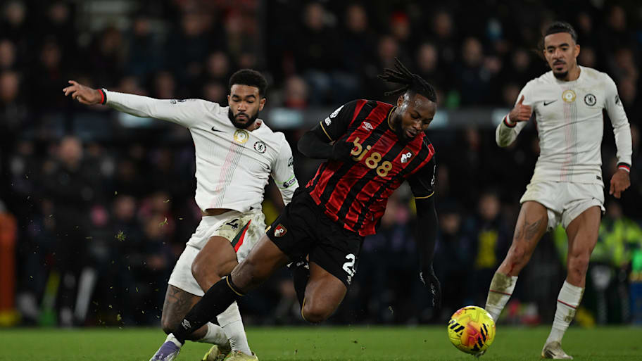 Antoine Semenyo (centre) getting tackled by Reece James (left).