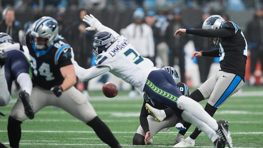 Dec 28, 2025; Charlotte, North Carolina, USA; Carolina Panthers quarterback Bryce Young (9) kicks a thirty-five yard field goal held by punter Sam Martin (6) (obscured) against Seattle Seahawks safety Nick Emmanwori (3) during the second quarter at Bank of America Stadium. Mandatory Credit: Jim Dedmon-Imagn Images