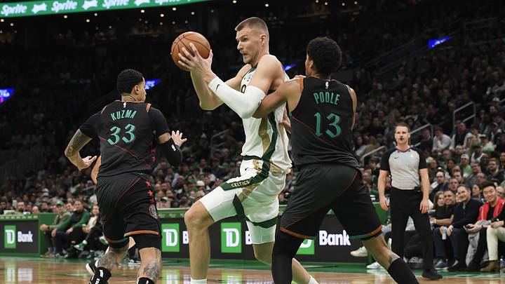 Feb 9, 2024; Boston, Massachusetts, USA; Washington Wizards guard Jordan Poole (13) defends Boston Celtics center Kristaps Porzingis (8) during the second half at TD Garden. Mandatory Credit: Bob DeChiara-Imagn Images
