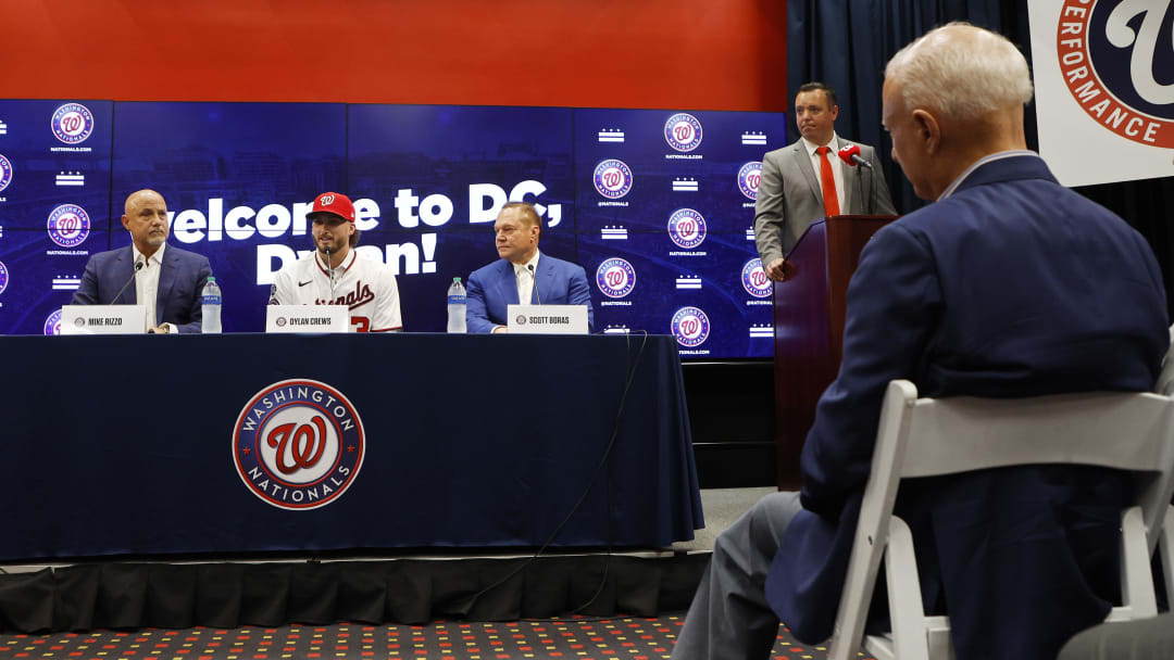 Jul 22, 2023; Washington, District of Columbia, USA; Washington Nationals principal owner Mark Lerner (R) listens in the audience as Nationals' first round draft pick outfielder Dylan Crews (M) speaks at an introductory press conference prior to the Nationals' game against the San Francisco Giants at Nationals Park.