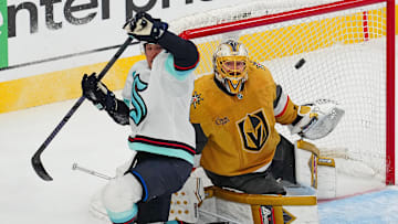 Apr 10, 2025; Las Vegas, Nevada, USA; Vegas Golden Knights goaltender Adin Hill (33) watches a loose puck behind Seattle Kraken defenseman Brandon Montour (62) during the third period at T-Mobile Arena. Mandatory Credit: Stephen R. Sylvanie-Imagn Images