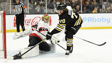 Mar 19, 2024; Boston, Massachusetts, USA;  Boston Bruins center Jesper Boqvist (70) tucks the puck past Ottawa Senators goaltender Joonas Korpisalo (70) during the third period at TD Garden. Mandatory Credit: Bob DeChiara-Imagn Images
