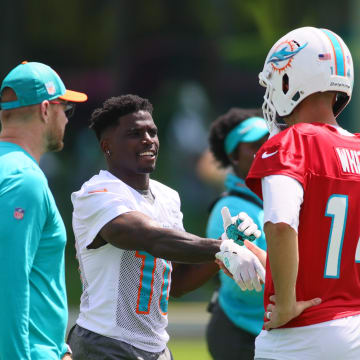 Jun 4, 2024; Miami Gardens, FL, USA; Miami Dolphins wide receiver Tyreek Hill (10) shakes hands with quarterback Mike White (14) during mandatory minicamp at Baptist Health Training Complex. 