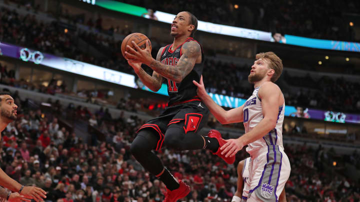 Feb 16, 2022; Chicago, Illinois, USA; Chicago Bulls forward DeMar DeRozan (11) shoots past Sacramento Kings forward Domantas Sabonis (10) during the second quarter at the United Center. 