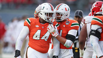 Dec 28, 2023; Bronx, NY, USA; Miami Hurricanes defensive lineman Rueben Bain Jr. (44) and linebacker Francisco Mauigoa (51) celebrates after a defensive stop during the first half of the 2023 Pinstripe Bowl against the Rutgers Scarlet Knights at Yankee Stadium. Mandatory Credit: Vincent Carchietta-Imagn Images