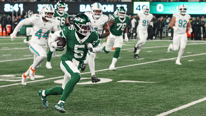 Jan 5, 2025; East Rutherford, New Jersey, USA; New York Jets wide receiver Garrett Wilson (5) gains yards after catch as Miami Dolphins linebacker Chop Robinson (44) pursues during the first half at MetLife Stadium. Mandatory Credit: Vincent Carchietta-Imagn Images Jan 5, 2025; East Rutherford, New Jersey, USA; New York Jets wide receiver Garrett Wilson (5) gains yards after catch as Miami Dolphins linebacker Chop Robinson (44) pursues during the first half at MetLife Stadium. Mandatory Credit: Vincent Carchietta-Imagn Images