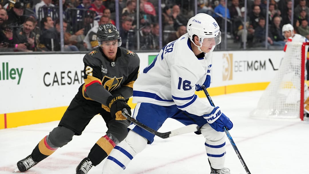 Oct 24, 2022; Las Vegas, Nevada, USA; Toronto Maple Leafs right wing Mitchell Marner (16) takes a slash from Vegas Golden Knights defenseman Zach Whitecloud (2) during the first period at T-Mobile Arena. Mandatory Credit: Stephen R. Sylvanie-Imagn Images