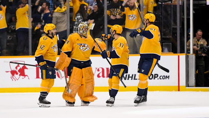 Jan 16, 2025; Nashville, Tennessee, USA;  Nashville Predators goaltender Juuse Saros (74) celebrates the win with his teammates against the Chicago Blackhawks during the overtime period at Bridgestone Arena. Mandatory Credit: Steve Roberts-Imagn Images