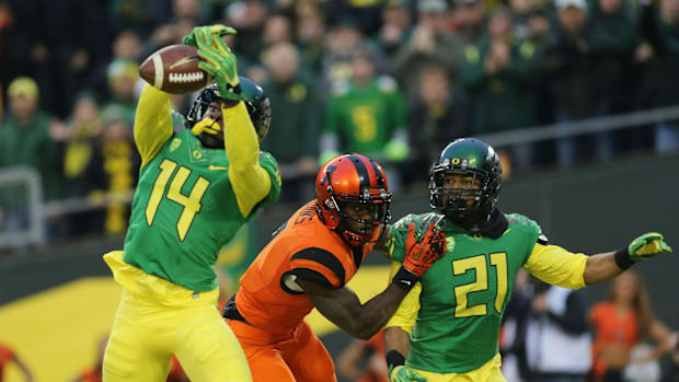 Oregon's Ifo Ekpre-Olomu (left) intercepts a pass in the end zone intended for Oregon State's Brandin Cooks