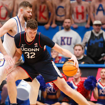 Donovan Clingan drives on Hunter Dickinson during UConn and Kansas's most recent meeting in 2023.