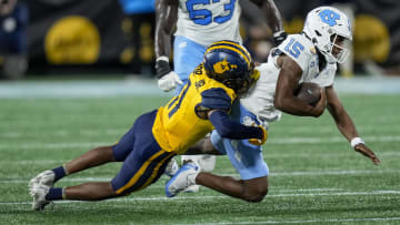 Dec 27, 2023; Charlotte, NC, USA; West Virginia Mountaineers cornerback Beanie Bishop Jr. (11) tackles North Carolina Tar Heels quarterback Conner Harrell (15) during the first half at Bank of America Stadium. Mandatory Credit: Jim Dedmon-USA TODAY Sports