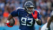 Tennessee Titans defensive tackle T'Vondre Sweat returns the ball after stripping it from Cincinnati Bengals quarterback Joe Burrow.