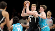 Dec 1, 2025; Brooklyn, New York, USA; Brooklyn Nets forward Danny Wolf (2) looks to pass the ball against Charlotte Hornets guards Kon Knueppel (7) and Collin Sexton (8) during the first quarter at Barclays Center. Mandatory Credit: Brad Penner-Imagn Images