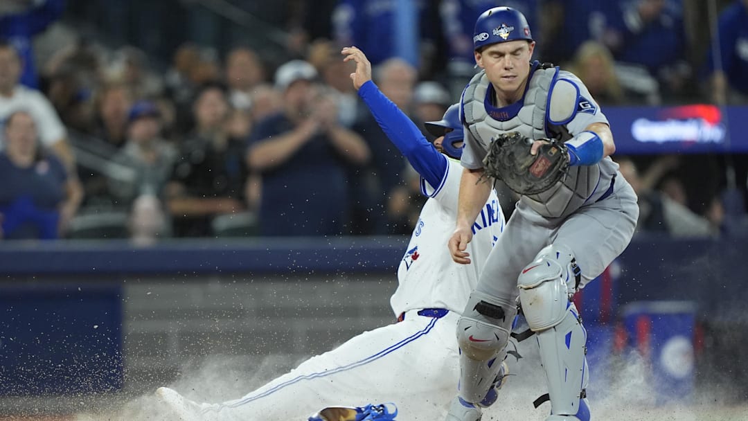 Nov 1, 2025; Toronto, Ontario, CAN; Toronto Blue Jays second baseman Isiah Kiner-Falefa (7) is out against Los Angeles Dodgers catcher Will Smith (16) in the ninth inning during game seven of the 2025 MLB World Series at Rogers Centre. Mandatory Credit: John E. Sokolowski-Imagn Images