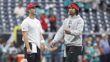 Dec 15, 2024; Houston, Texas, USA; Houston Texans quarterback C.J. Stroud (right) and quarterback Davis Mills warm up before the game against the Miami Dolphins at NRG Stadium. Mandatory Credit: Troy Taormina-Imagn Images