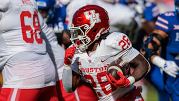 Oct 19, 2024; Kansas City, Missouri, USA; Houston Cougars running back Re'Shaun Sanford II (26) runs the ball against the Kansas Jayhawks during the first quarter at GEHA Field at Arrowhead Stadium. Mandatory Credit: William Purnell-Imagn Images
