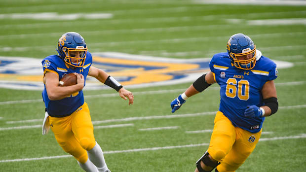 South Dakota State's Mark Gronowski runs with the ball alongside Mason McCormick (60)