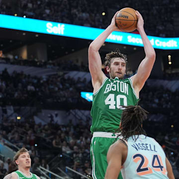 Mar 29, 2025; San Antonio, Texas, USA;  Boston Celtics center Luke Kornet (40) rebounds a ball in front of San Antonio Spurs guard Devin Vassell (24) in the second half at Frost Bank Center. Mandatory Credit: Daniel Dunn-Imagn Images