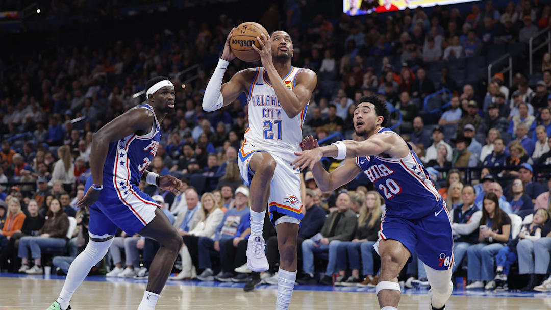 Dec 28, 2025; Oklahoma City, Oklahoma, USA; Oklahoma City Thunder guard Aaron Wiggins (21) drives between Philadelphia 76ers center Adem Bona (30) and guard Jared McCain (20) during the second half at Paycom Center. Mandatory Credit: Alonzo Adams-Imagn Images Dec 28, 2025; Oklahoma City, Oklahoma, USA; Oklahoma City Thunder guard Aaron Wiggins (21) drives between Philadelphia 76ers center Adem Bona (30) and guard Jared McCain (20) during the second half at Paycom Center. Mandatory Credit: Alonzo Adams-Imagn Images