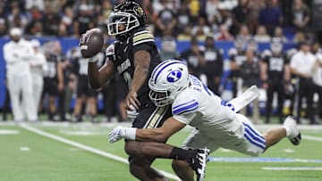 Dec 28, 2024; San Antonio, TX, USA; Colorado Buffaloes quarterback Shedeur Sanders (2) is tackled by Brigham Young Cougars safety Raider Damuni (3) during the second quarter at Alamodome. Mandatory Credit: Troy Taormina-Imagn Images