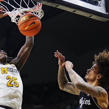 Feb 8, 2025; Columbia, Missouri, USA; Missouri Tigers guard Mark Mitchell (25) dunks the ball against Texas A&M Aggies forward Andersson Garcia (11) during the first half at Mizzou Arena. Mandatory Credit: Jay Biggerstaff-Imagn Images